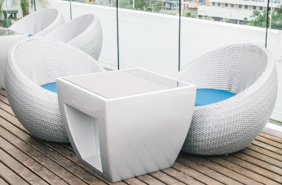 A cheap garden rattan furniture set that is painted white and displayed on a patio
