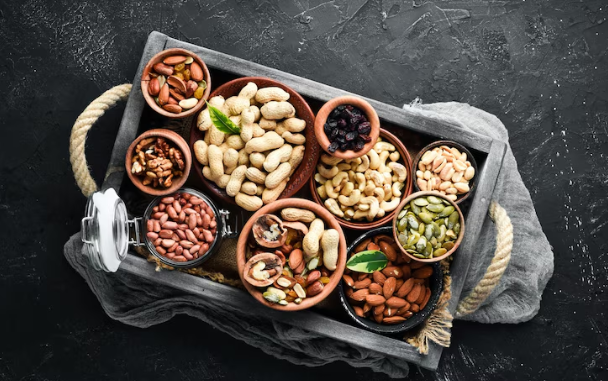 Prosecco cocktails with vodka: A variety of nuts placed in different containers in a picnic basket on a dark background