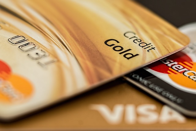A gold credit card and a black MasterCard with a blurry caption