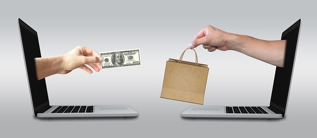 Debenhams men’s fragrance sale: Two laptops with half arm out, one has money the other a shopping bag