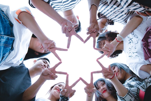 A group of friends forming a star with their hands for International Day of Friendship