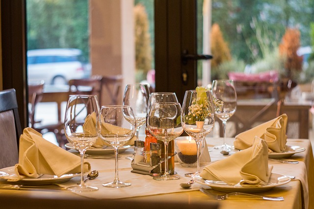 Table set in a restaurant with wine glasses, serviettes, and salt & pepper shaker, perfect for a cheese and wine night out.
