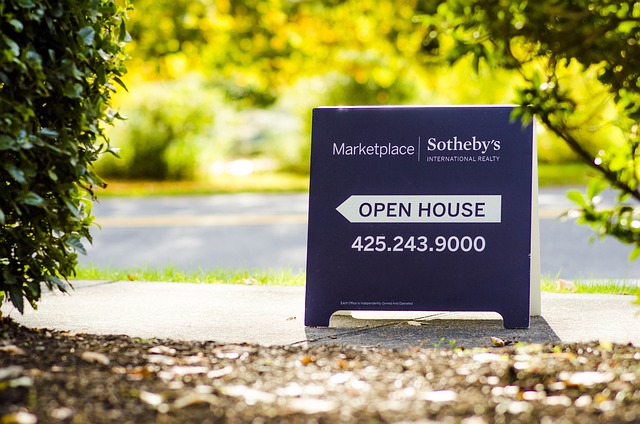 Image: Saving for a house: Open house signage on the curb filled with leaves. Saving for a house: Open house signage on the curb filled with leaves.