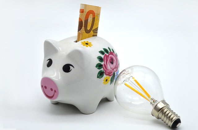 White piggy bank with money on the slot and a light bulb on the side
