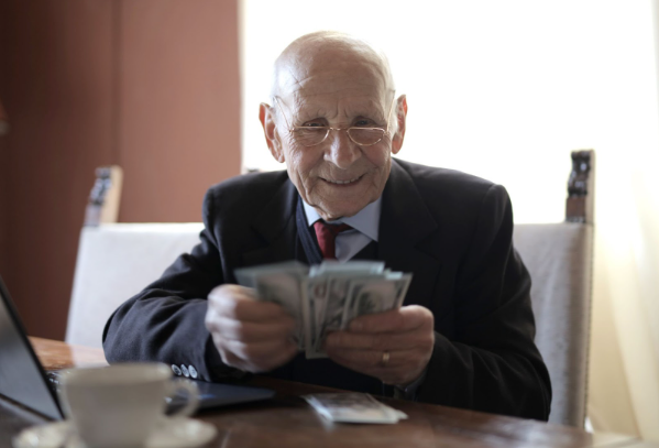 Image: Man smiling holding the money he saved from joining the money saving boiler challenge Man smiling holding the money he saved from joining the money saving boiler challenge