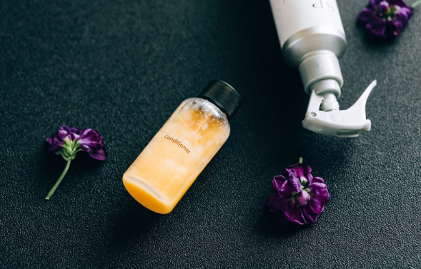 Image: Professional hair care products with purple flowers arranged around them. Professional hair care products with purple flowers arranged around them.