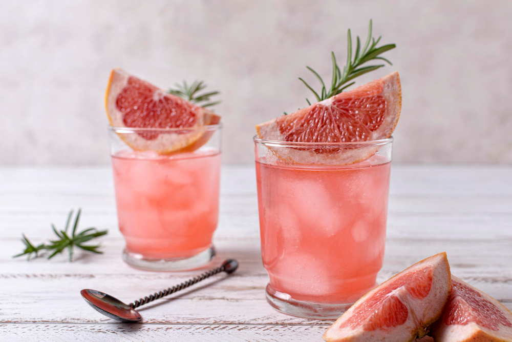Prosecco Cocktails With Vodka: Two glasses of grapefruit vodka cocktails with grapefruit slices on a table.