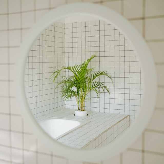 A small bathroom idea in the UK reflected on a round mirror with a white frame