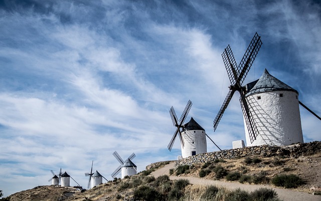 Windmills in Spain on an uneven dirt road.