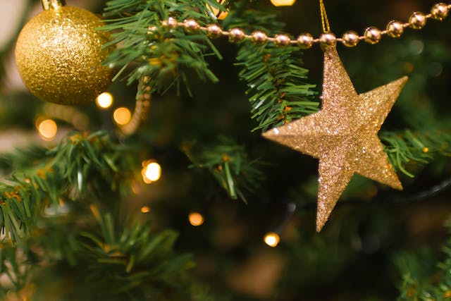 Real or fake Christmas tree: Christmas ornaments hanging from the branches of an artificial tree