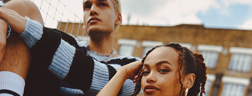 Image: A woman and man sitting outside an apartment building under a cloudy sky A woman and man sitting outside an apartment building under a cloudy sky