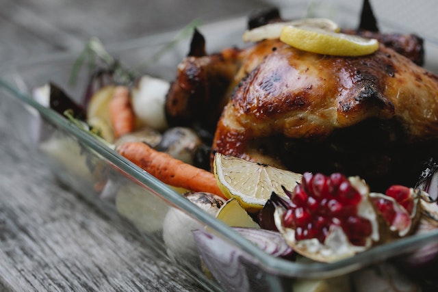 A freshly made roast dinner idea in a baking dish on an ashwood dining table