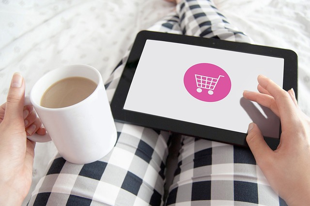 Michael Kors watches for ladies: A person sitting down wearing gingham pants carrying a coffee mug and a tablet with a cart image on the display.
