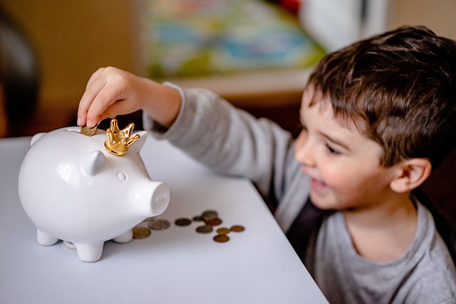 Little boy putting money in a piggy bank as the best child savings account in the UK.