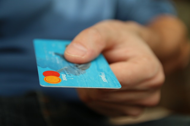 Credit card travel insurance: A man holding out his credit card to make a payment
