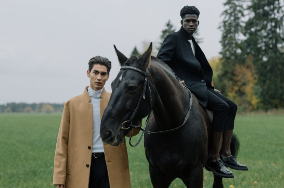 Image: Two men wearing men’s parka winter coats in a field with a black horse Two men wearing men’s parka winter coats in a field with a black horse