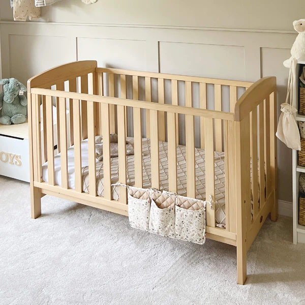 Image: A Boori cot and mattress standing on a white carpet in an off-white nursery A Boori cot and mattress standing on a white carpet in an off-white nursery