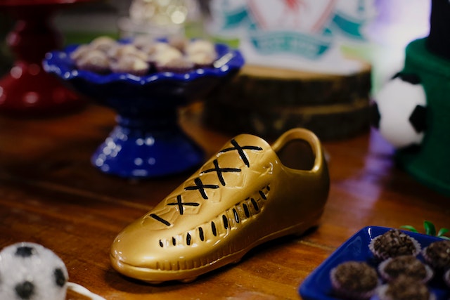A decorative football on a table with snacks on a table after planning a football party