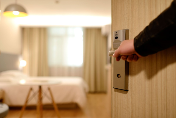 Image: A man opening up a room in a cheap hotel in Manchester. A man opening up a room in a cheap hotel in Manchester.