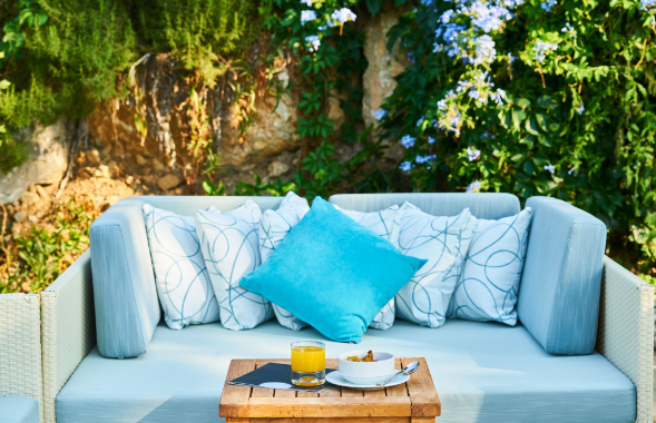 Image: The Range garden furniture outdoor sofa with blue cushions and a small table The Range garden furniture outdoor sofa with blue cushions and a small table