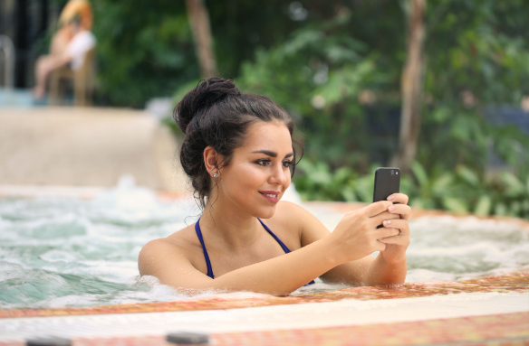 A woman in a hot tub smiling because she brought one of the eBay hot tubs for sale with a great deal.
