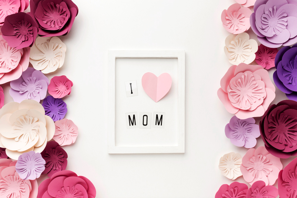 Image: Mother’s Day spa gifts: A variety of pink, purple, lavender and cream paper flowers and a card in the middle with a heart. Mother’s Day spa gifts: A variety of pink, purple, lavender and cream paper flowers and a card in the middle with a heart.
