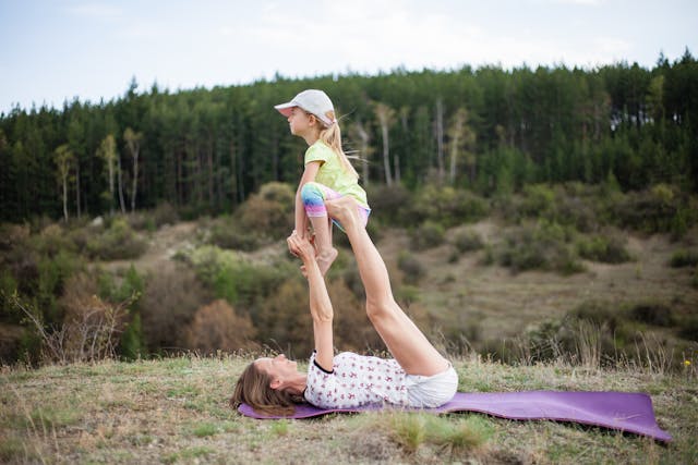 Image: What is acroyoga?: A mother and daughter practising acroyoga for beginners on the grass What is acroyoga?: A mother and daughter practising acroyoga for beginners on the grass