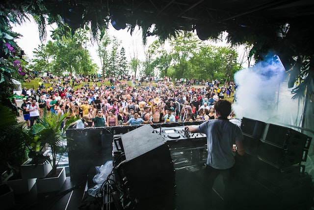 A DJ on a stage playing in front of a crowd at one of the UK music festivals