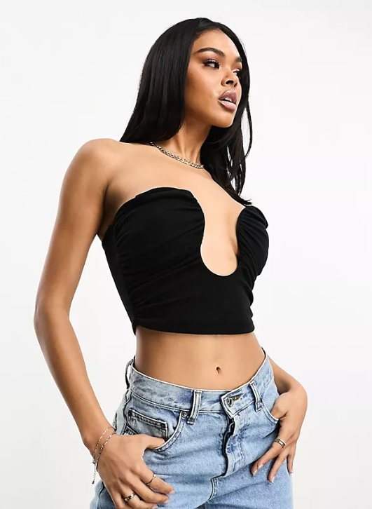 going out tops to wear with jeans: A model wearing a black crop top with blue jeans