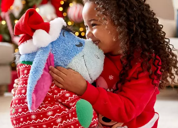 A girl holding her Christmas present from the Disney Gifts for Christmas range