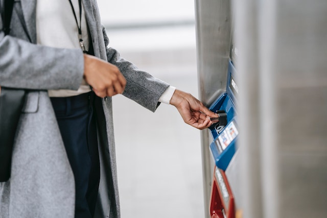 Travel credit cards: A woman paying for her ticket with an electronic machine