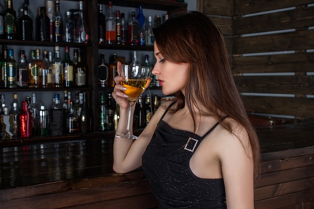 Majestic Wine Club: Lady sipping on a wine cocktail at a bar table with a variety of drinks in the background.