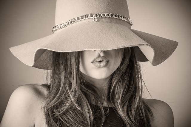 Female model wearing a hat with long hair image taken as a black and grey portrait.