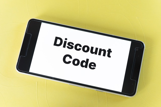 Smartphone with the discount code displayed on the screen on a yellow background.