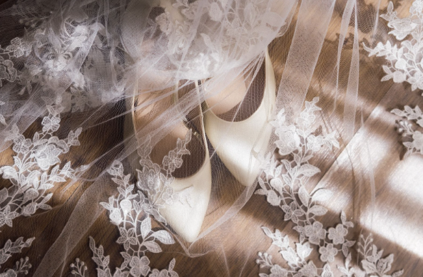 Wedding shoes under a white flower veil