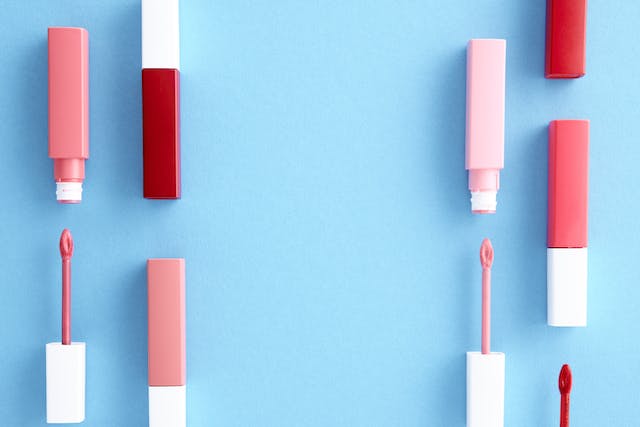 Image: Six tubes of red & blush lipstick and three lip gloss wands lying on a blue background Six tubes of red & blush lipstick and three lip gloss wands lying on a blue background