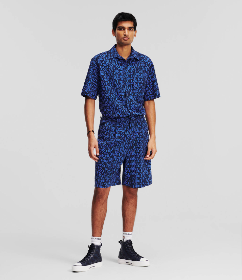 A model wearing blue Karl Logo Woven Shorts and Shirt from Karl Lagerfeld