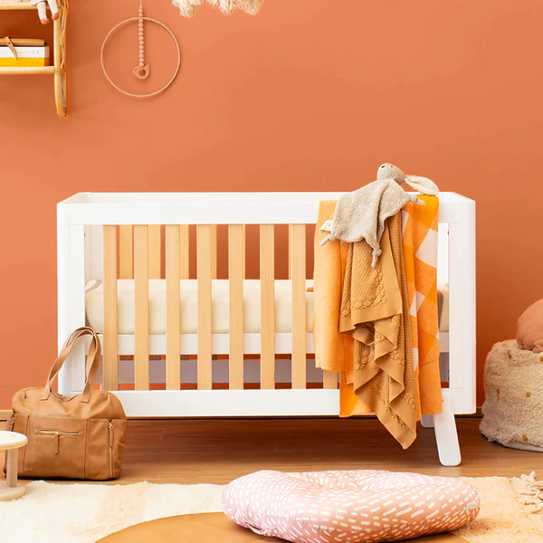 Image: A Turin cot from the Boori cots and mattresses range standing against an orange wall A Turin cot from the Boori cots and mattresses range standing against an orange wall