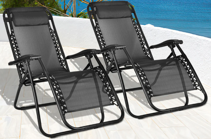 Rattan garden furniture sets: Two black sun loungers placed on a deck next to a lake.