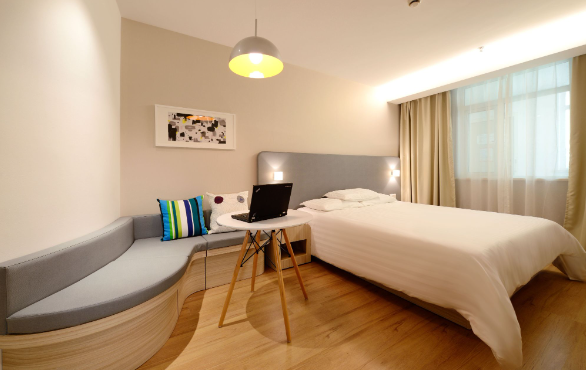 Image: A hotel room with a bed, day chair and a side table with a laptop: A cheap hotel in Manchester A hotel room with a bed, day chair and a side table with a laptop: A cheap hotel in Manchester