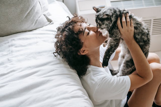 Happy International Cat Day: A woman holding her cat and caressing its nose