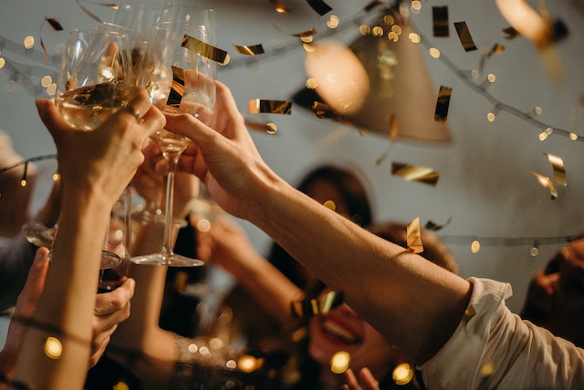 A group of people toasting wine glasses at a party for the FA Cup Final 2023