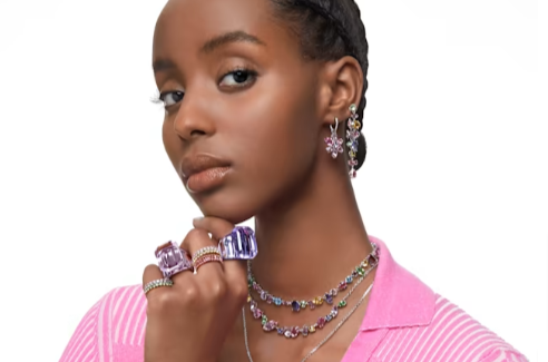 A woman wearing a multi-coloured Swarvoski necklace and bracelet set.