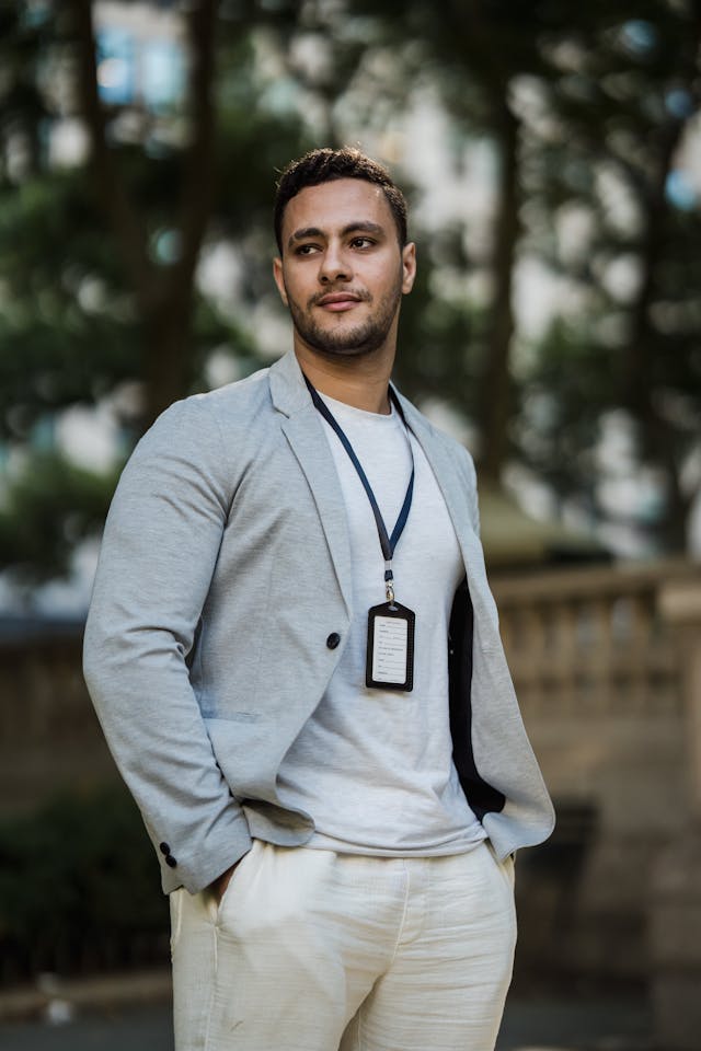 A man dressed in business casual clothes for men and an ID card for the office