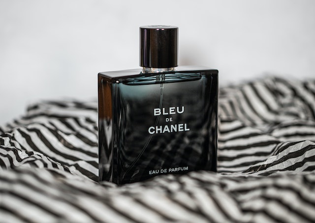 Eau de toilette vs eau de parfum: A black bottle of eau de parfum on a black and white striped paper