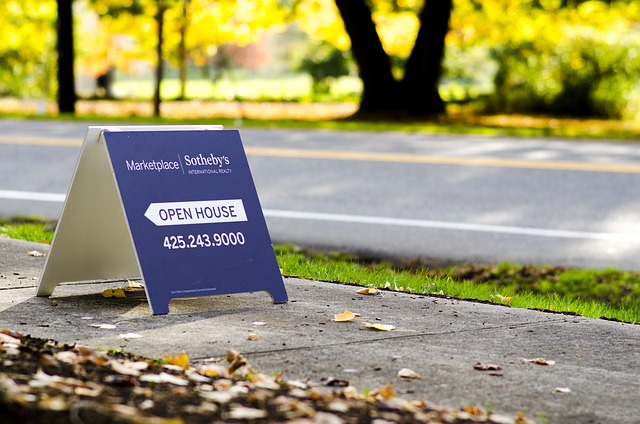 Costs For Selling A House: Open house sign on the pavement with leaves on the sidewalk.