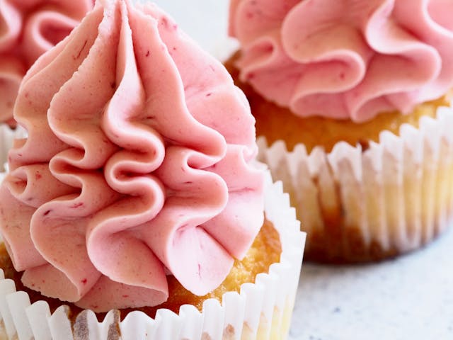 Mother’s Day cupcake ideas: Three pink lemonade cupcakes standing on a quartz countertop
