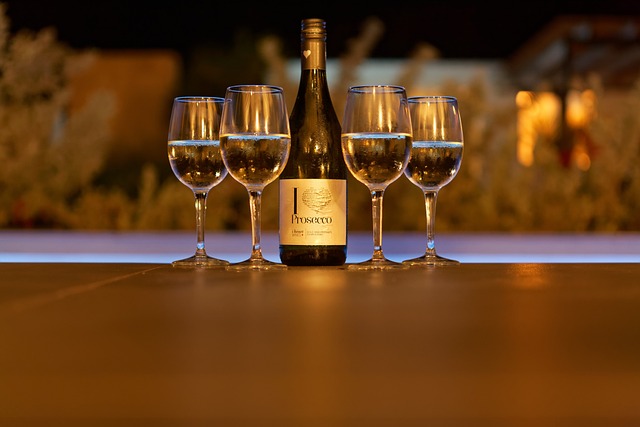Majestic wine Prosecco: Bottle of Prosecco with 4 glasses filled with champagne with a blurry background.