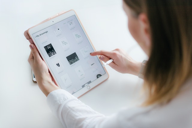 A woman using her iPad instead of paper to draw icons for Earth Day 2023