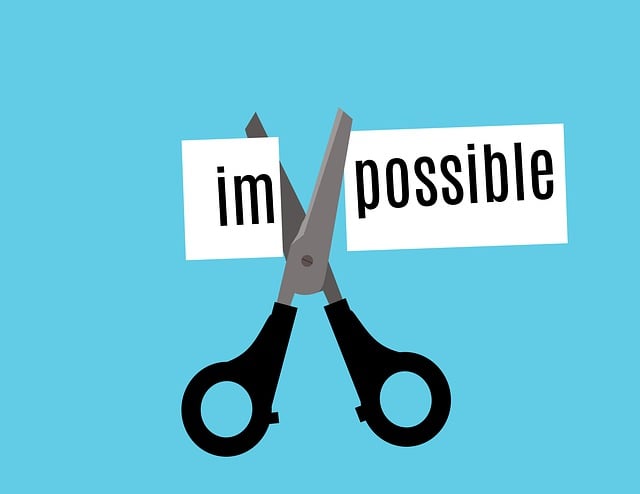 Image: New Year savings challenge: Big black scissors cutting through the word impossible with a light blue background New Year savings challenge: Big black scissors cutting through the word impossible with a light blue background